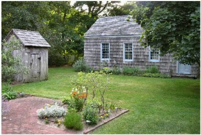 View of the 1734 smokehouse, 1822 one-room schoolhouse, and a corner of the 19th century herb garden. The late 19th century '4-holer' outhouse is located behind the schoolhouse. View of the 1734 smokehouse, 1822 one-room schoolhouse, and a corner of the 19th century herb garden. The late 19th century '4-holer' outhouse is located behind the schoolhouse.