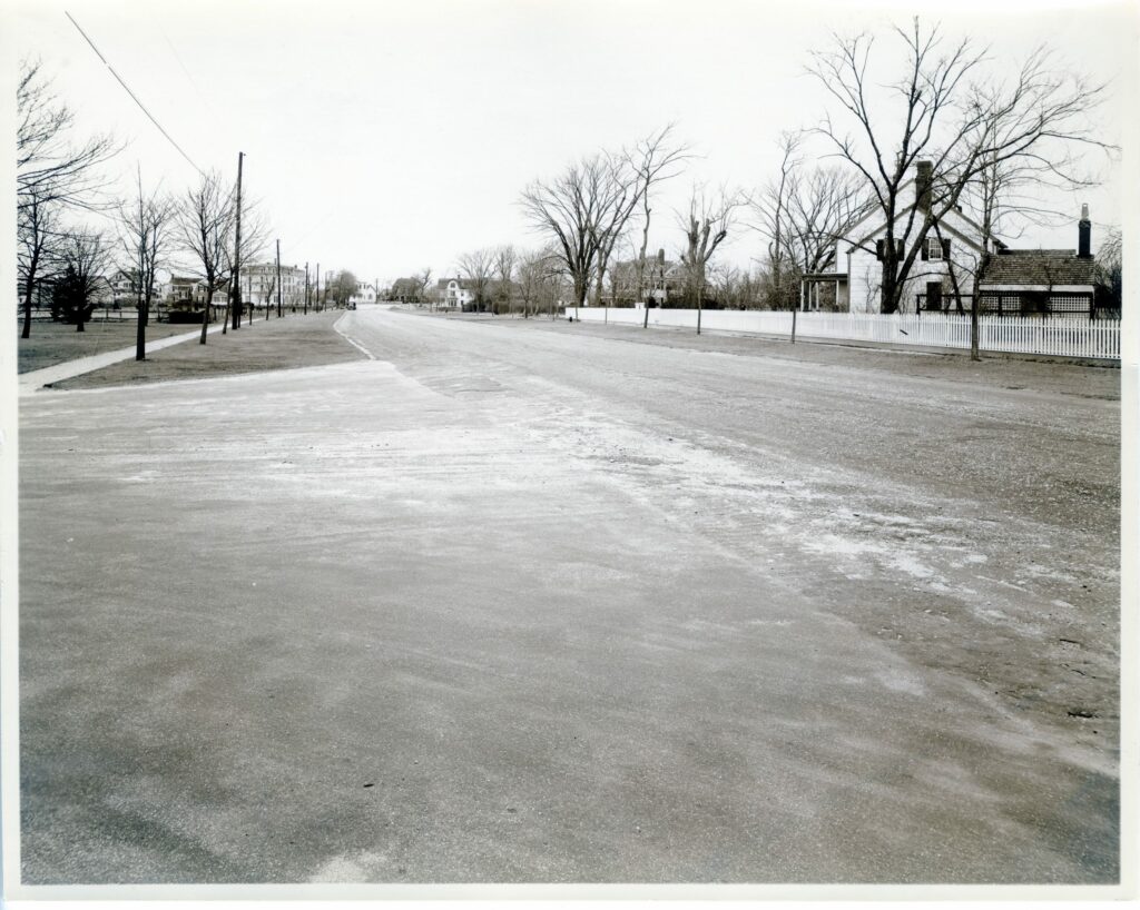 Quogue Street, looking west. “Miss Mary Post’s Cottage,” mid-18th century, “Hermitage,” ca. 1890, and Cooper House Annex, on right. On left, 67 Quogue Street, ca. 1907, Quogue House, Presbyterian Chapel, ca. 1868, and “Fieldmouse,” ca. 1890.